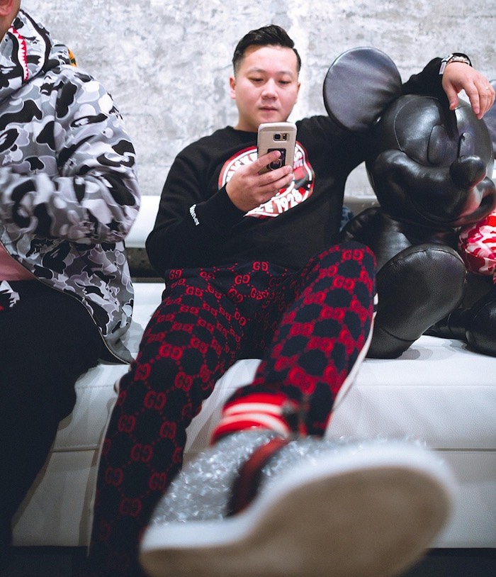 Chuck Wang in the Hypebeast Room at Vue, next to a leather Mickey Mouse