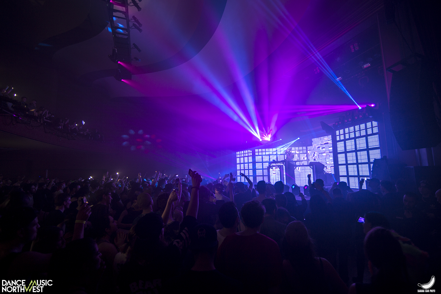 a stage and a crowd with blue and purple lights