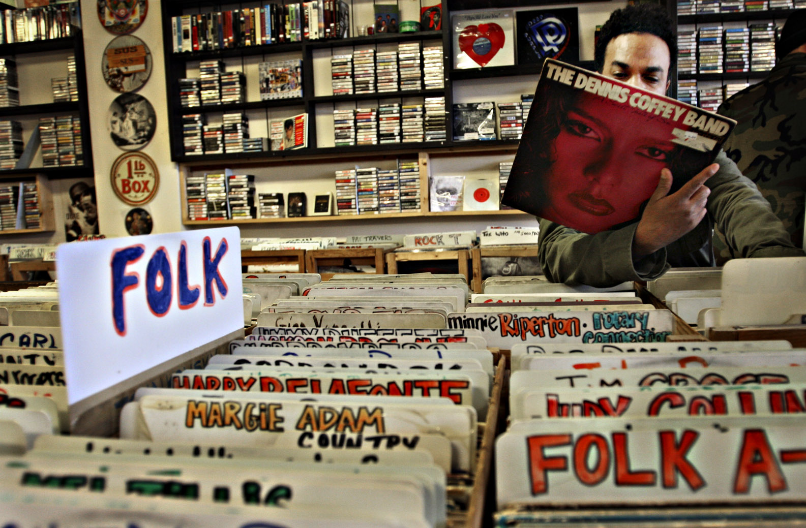 A customer looks at a folk record in a record store