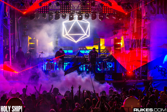 bright red and blue stage lights highlight duo ODESZA while fans dance. 