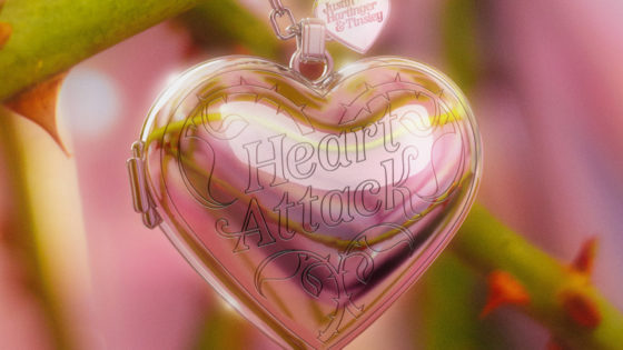 A heart pendant hanging on rose stems with a pink background