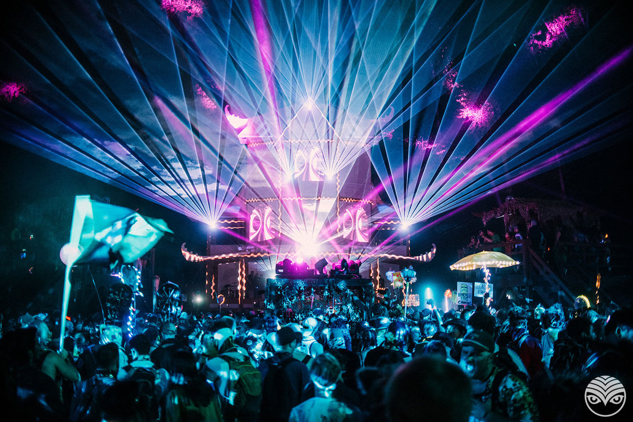 Image of Shambhala stage at night with purple lasers and blue lights.
