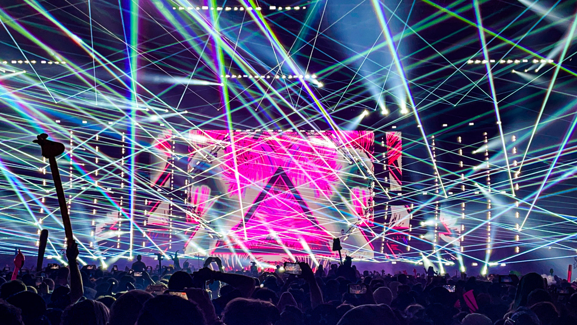 Excision's Thunderdome 2023 main stage with white lasers and a pink triangle on the video screen