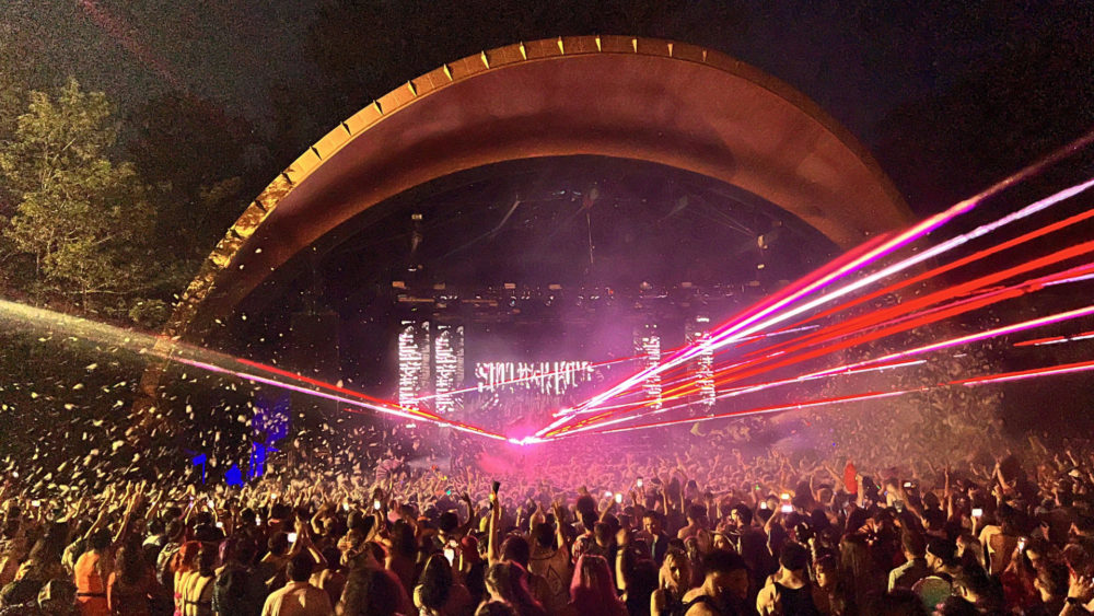 Sullivan King performing with red and white lasers and foam floating above the crowd