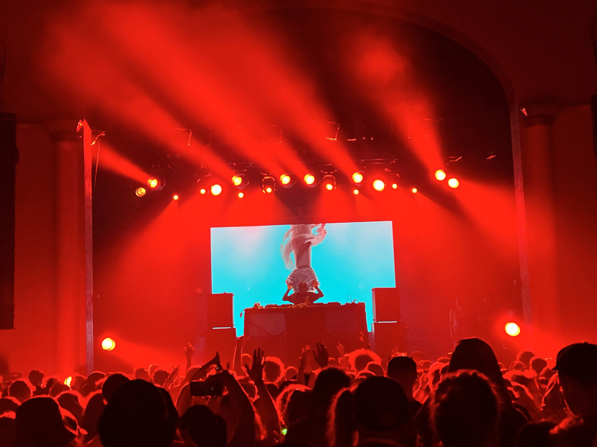 Phase one performing at the Mcdonald Theatre with Red lights and light blue visuals.