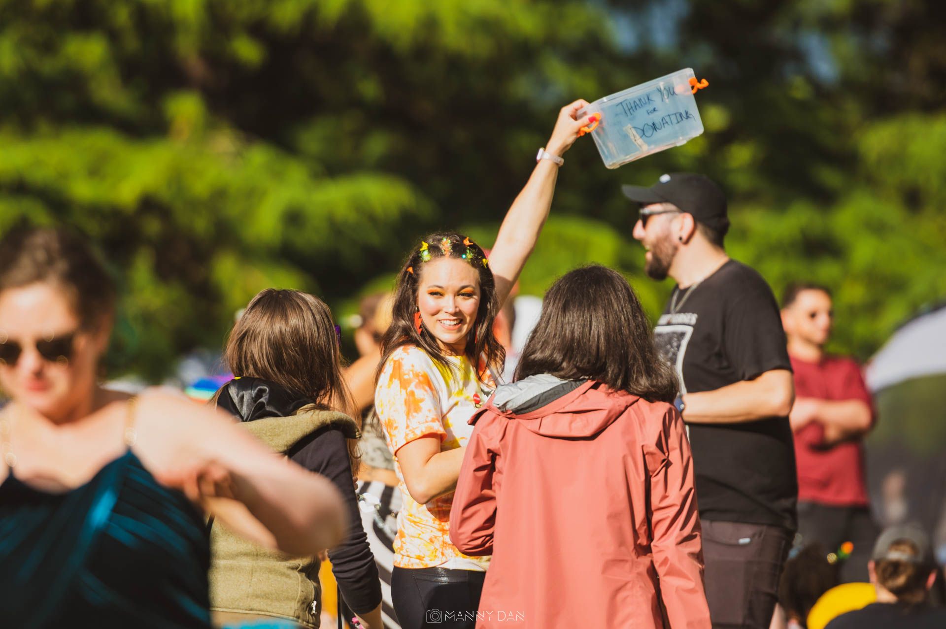 Image displays woman holding bucket for donations at Parke Diem (free festival)