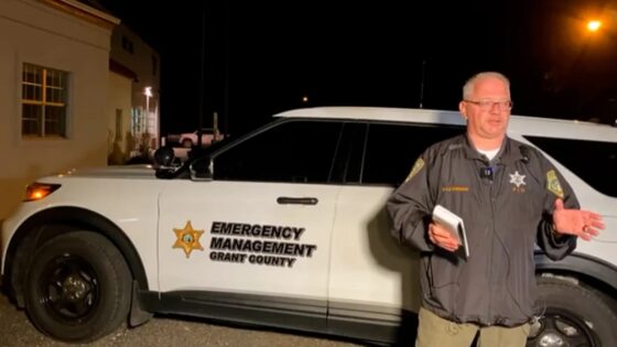 Emergency response officer standing in front of white SUV reporting on the shooting at Beyond Wonderland at The Gorge