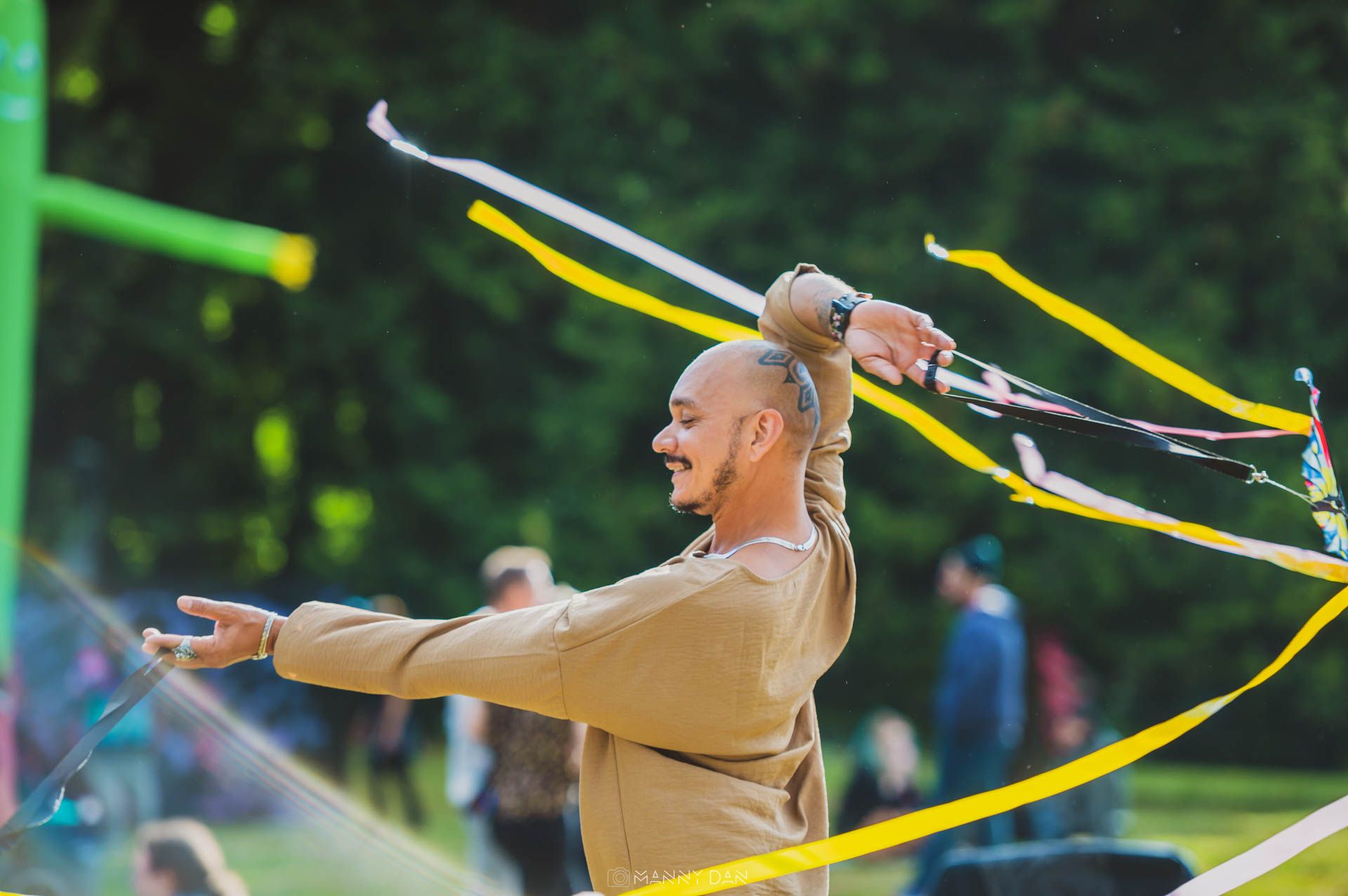 Image displays someone wearing tan shirt using flow arts (free festival)