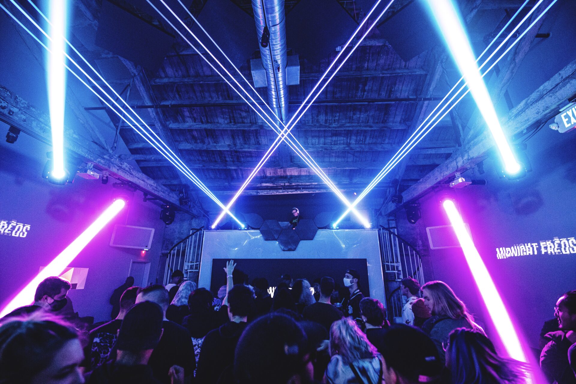 Bindy Performing at Vue Nightclub with a high stage and blue beams of light across the room 