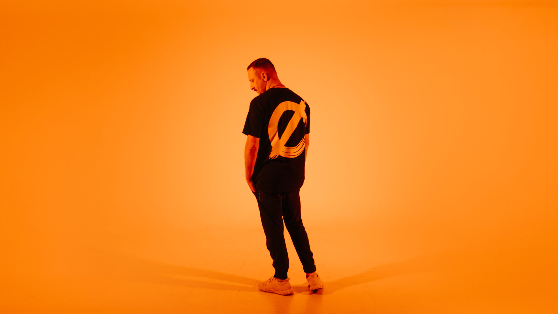 Marten Horger standing in front of orange wall