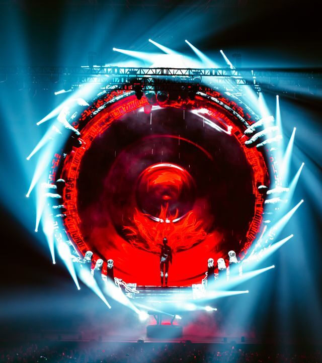A digital picture of a blue portal swirling around a red center, with Rezz standing inside.