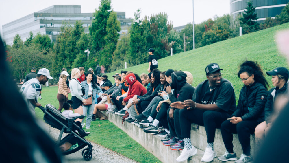 Many Walk Club participants sitting in the grass at Myrtle Edwards Park in Seattle