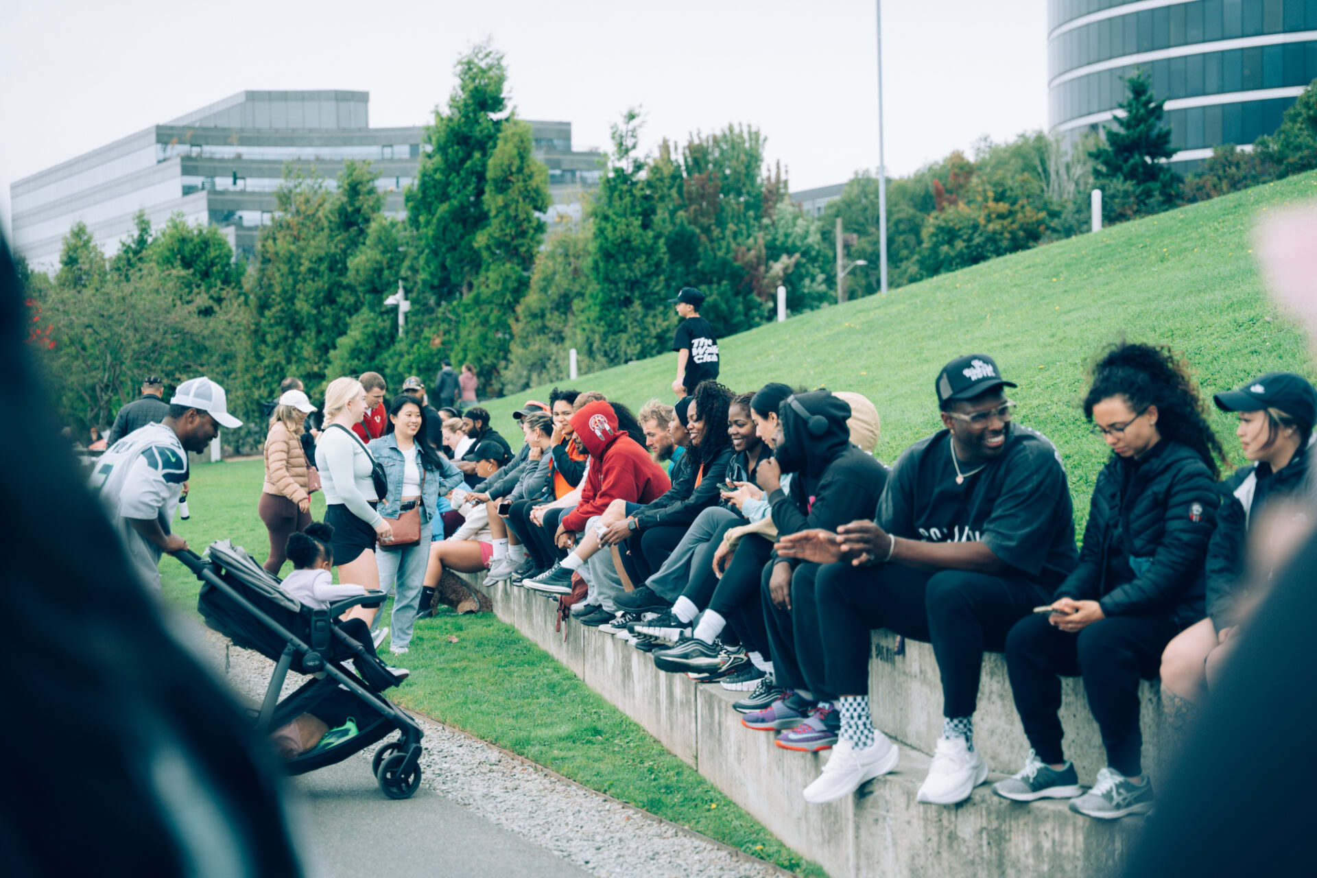 Many Walk Club participants sitting in the grass at Myrtle Edwards Park in Seattle