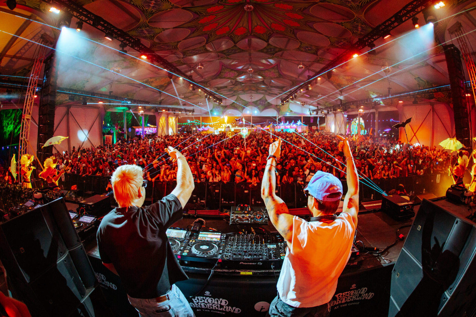 photo of Sidepiece DJ'ing at the Caterpillar Garden stage with lasers and the crowd in the background
