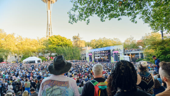 Looking at the Fisher Stage over the crowd with the sunny Space Needle in the background at Bumbershoot 2026