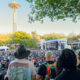 Looking at the Fisher Stage over the crowd with the sunny Space Needle in the background at Bumbershoot 2026